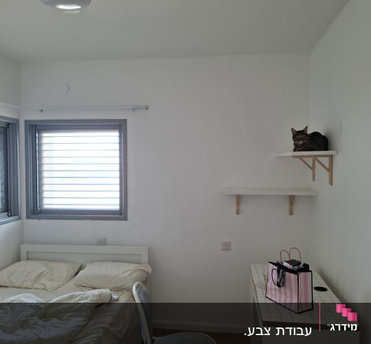 חדר שינה מרוהט לאחר צביעת קירות ותקרה בצבע לבן
